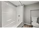 Bathroom showcasing a white shower-tub and toilet over wood-look flooring at 2519 Lauderdale Ne Dr, Atlanta, GA 30345