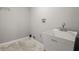 Functional laundry room featuring a utility sink, hook rack, and tile flooring, ready for appliances at 2519 Lauderdale Ne Dr, Atlanta, GA 30345