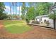 Backyard with manicured lawn, mature trees, and cozy patio at 2885 Laurel Green Ct, Roswell, GA 30076