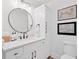 Charming bathroom featuring a stylish white vanity, round mirror, and elegant fixtures; perfect for modern living at 2885 Laurel Green Ct, Roswell, GA 30076
