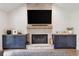Elegant fireplace with stone surround, wooden mantle, custom blue cabinets, and TV at 2885 Laurel Green Ct, Roswell, GA 30076