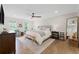 Bright main bedroom with hardwood floors, ceiling fan, neutral walls, bench, and large windows at 2885 Laurel Green Ct, Roswell, GA 30076