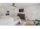 Main bedroom showcasing hardwood floors, ceiling fan, TV, dresser, a door, and a view of the bathroom at 2885 Laurel Green Ct, Roswell, GA 30076
