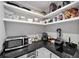 Organized pantry with open shelving, microwave, and sink, perfect for storage and prep at 2885 Laurel Green Ct, Roswell, GA 30076