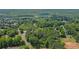 Expansive aerial view of a tree-lined neighborhood with glimpses of rooftops below at 3852 Drew Campground Rd, Cumming, GA 30040