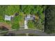 Aerial view of a quaint home surrounded by lush trees, featuring a driveway and quiet surroundings at 3852 Drew Campground Rd, Cumming, GA 30040