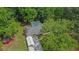 An aerial view shows the home, driveway, canopy, wooded backyard, and storage shed at 3852 Drew Campground Rd, Cumming, GA 30040