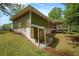 Rear view of home showcasing covered back porch and lower level entrance and natural surroundings at 3852 Drew Campground Rd, Cumming, GA 30040