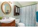 Well-lit bathroom features a stylish vanity, an oval mirror, and a shower with patterned curtain at 3852 Drew Campground Rd, Cumming, GA 30040