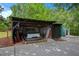 Open carport adjacent to green storage building with room to park one automobile at 3852 Drew Campground Rd, Cumming, GA 30040