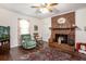Comfortable living room featuring a brick fireplace, vintage decor, and hardwood floors at 3852 Drew Campground Rd, Cumming, GA 30040