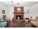Cozy living area featuring a brick fireplace, comfortable seating, and hardwood floors at 3852 Drew Campground Rd, Cumming, GA 30040