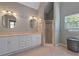 Neutral bathroom with a double sink vanity, bright lighting, and a glass-enclosed shower stall at 4423 Windsor Oaks Cir, Marietta, GA 30066