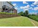 Expansive backyard featuring a retaining wall, lush lawn, and verdant trees with an expansive view at 5770 Bridleton Xing, Suwanee, GA 30024