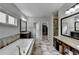 Bright bathroom with tiled floors, soaking tub, granite countertops, and double sink vanity at 5770 Bridleton Xing, Suwanee, GA 30024
