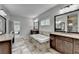 Bright bathroom with tiled floors, soaking tub, granite countertops, and double sink vanity at 5770 Bridleton Xing, Suwanee, GA 30024