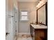 Bathroom featuring granite countertops, neutral walls, a window, and a decorative mirror at 5770 Bridleton Xing, Suwanee, GA 30024