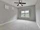 Bedroom with gray walls, light carpet, white trim, a ceiling fan, and a window providing a view at 5770 Bridleton Xing, Suwanee, GA 30024