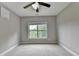 Bedroom with gray walls, light carpet, white trim, and a window providing a treed view at 5770 Bridleton Xing, Suwanee, GA 30024