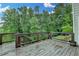 Open wooden deck with railings overlooks a wooded area, providing a scenic and private outdoor space at 5770 Bridleton Xing, Suwanee, GA 30024