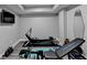 Home gym with modern fitness equipment, light wood flooring, and a wall-mounted TV at 5770 Bridleton Xing, Suwanee, GA 30024
