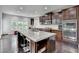 Spacious kitchen featuring an island with granite countertops, stainless appliances, and dark wood cabinets at 5770 Bridleton Xing, Suwanee, GA 30024