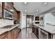 Open kitchen with stainless appliances, granite countertops, large island, and hardwood flooring at 5770 Bridleton Xing, Suwanee, GA 30024