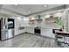 Kitchen features stainless steel appliances, white cabinets, floating wood shelves, and modern finishes at 5770 Bridleton Xing, Suwanee, GA 30024