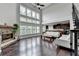 Spacious living room with a stone fireplace, hardwood floors, and large windows at 5770 Bridleton Xing, Suwanee, GA 30024