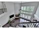 Open-concept living room with a fireplace, floor-to-ceiling windows, and hardwood floors at 5770 Bridleton Xing, Suwanee, GA 30024