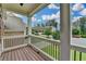 Covered porch with wood flooring and white columns, offering a charming outdoor seating area at 5770 Bridleton Xing, Suwanee, GA 30024