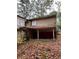 An exterior shot of the back of a house with rotting eaves and a yard full of leaves at 711 Alfred Nw Rd, Atlanta, GA 30331