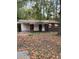 An exterior shot of a house with boarded up windows, a yard full of leaves, and a roof in need of repair at 711 Alfred Nw Rd, Atlanta, GA 30331