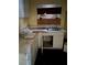 A dirty kitchen with a stainless steel sink, dingy cabinets, and a boarded up window at 711 Alfred Nw Rd, Atlanta, GA 30331