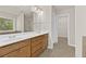 Bathroom featuring double sinks, wood cabinets, a large mirror, and a separate walk-in closet at 2550 Trelipe Dr, Lawrenceville, GA 30044