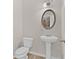 Classic powder room with pedestal sink and oval mirror at 2550 Trelipe Dr, Lawrenceville, GA 30044