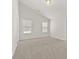 Spacious bedroom featuring neutral carpet and vaulted ceilings with two windows at 2550 Trelipe Dr, Lawrenceville, GA 30044