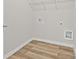 The laundry room includes wooden-look flooring, utility hookups, and shelving at 2550 Trelipe Dr, Lawrenceville, GA 30044