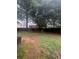 Fenced backyard with lawn, mature shade trees, and a deck in the back for outdoor enjoyment at 458 Vinings Vintage Cir, Mableton, GA 30126