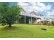 View of the backyard featuring a covered deck area and lush green lawn at 528 Savannah Rose Way, Lawrenceville, GA 30045