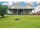 Expansive backyard featuring a covered patio, green lawn, and neutral siding at 528 Savannah Rose Way, Lawrenceville, GA 30045
