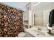 Cozy bathroom featuring a white vanity, cabinet, floral shower curtain and modern fixtures at 528 Savannah Rose Way, Lawrenceville, GA 30045