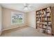 Comfortable bedroom showcasing a large window, cozy carpeting, and a built-in bookcase filled with decor at 528 Savannah Rose Way, Lawrenceville, GA 30045