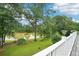 Picturesque lake view from the home's deck featuring lush green grass and mature trees at 528 Savannah Rose Way, Lawrenceville, GA 30045
