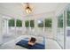 Bright sunroom with tile flooring, ceiling fan, and sliding glass doors leading to a deck with outdoor views at 528 Savannah Rose Way, Lawrenceville, GA 30045