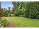 Expansive backyard featuring lush green grass and mature trees, perfect for outdoor activities and relaxation at 5605 Copper Creek Pass, Cumming, GA 30040