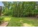 Serene backyard showcasing a well-maintained lawn, bordered by mature trees offering plenty of shade at 5605 Copper Creek Pass, Cumming, GA 30040