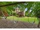 Charming backyard with a wooden swing set, complemented by a view of the deck and home's exterior at 5605 Copper Creek Pass, Cumming, GA 30040