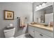 Cozy bathroom with a single sink vanity, granite countertop, and a shower with a patterned curtain at 5605 Copper Creek Pass, Cumming, GA 30040