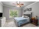 Comfortable bedroom with plush carpeting, a blue patterned bedspread, and a dresser for storage at 5605 Copper Creek Pass, Cumming, GA 30040